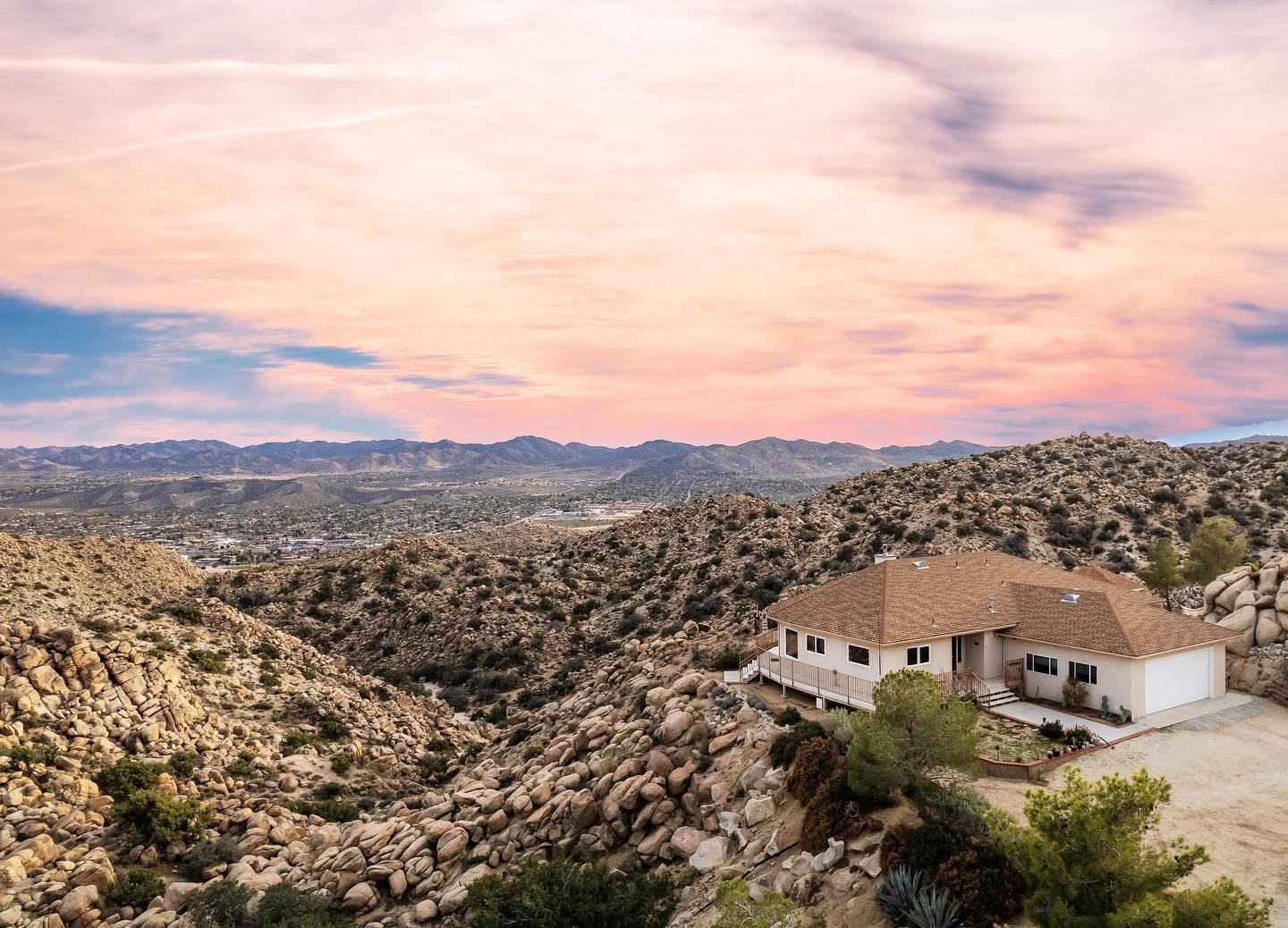 Aerial view of the Infinite Horizon home on its hilltop acreage under a pink desert sunset near Joshua Tree National Park
