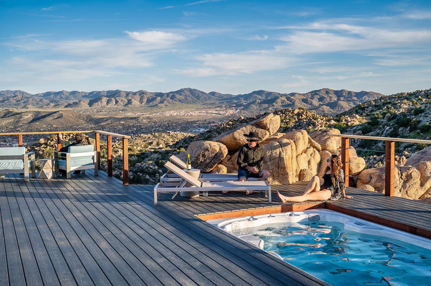 Guests relaxing at the private hot tub and pool spa on the deck overlooking Yucca Valley near Joshua Tree