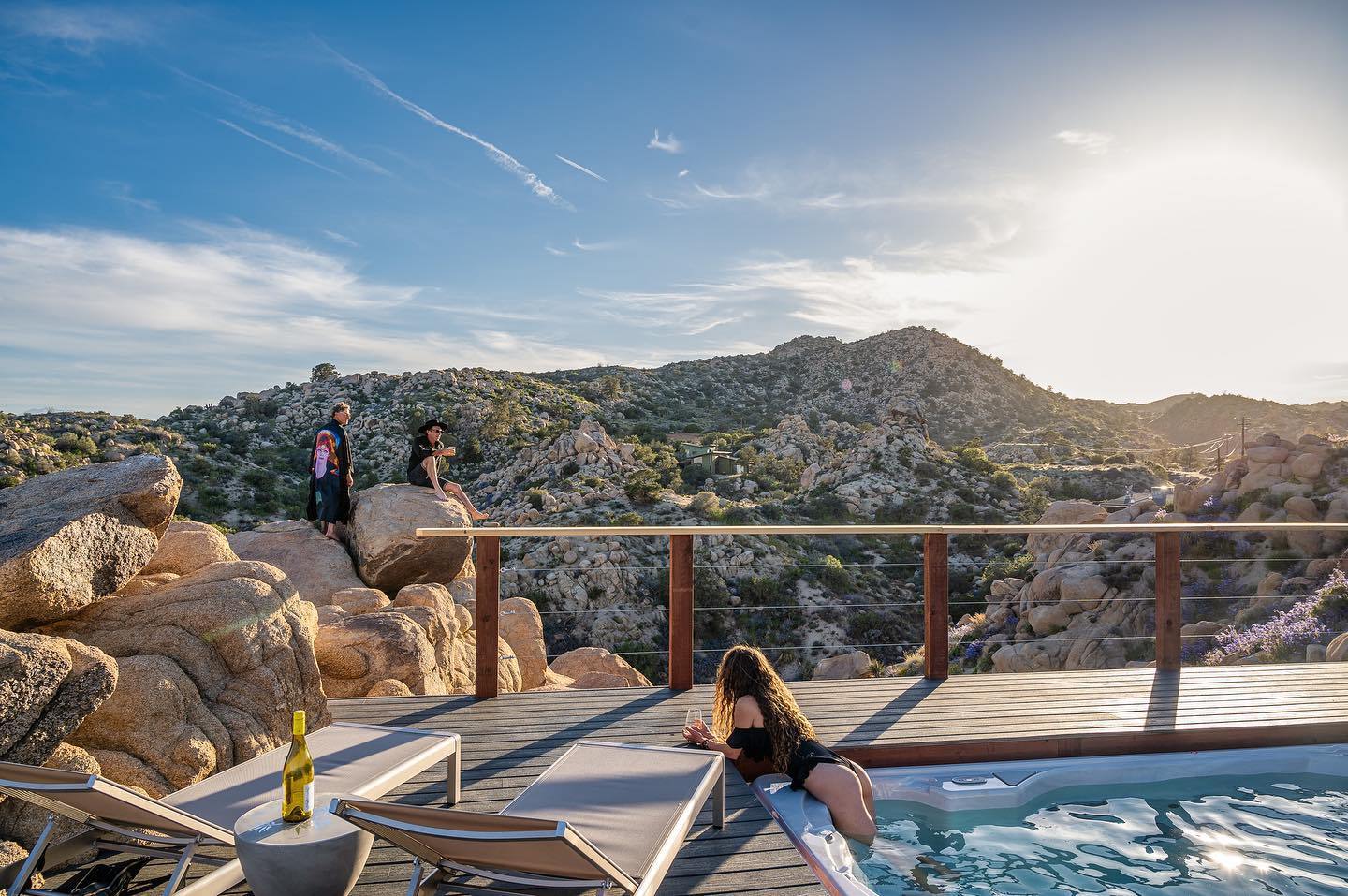 Hot tub and lounge deck with an unbroken boulder-and-mountain view at this Joshua Tree pool rental